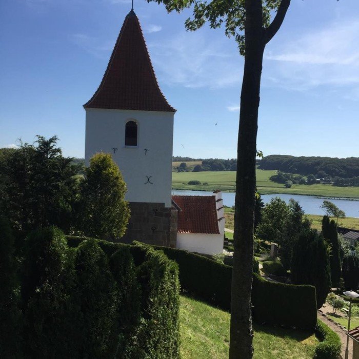 Gravlev kirke med Gravlev Sø i baggrunden